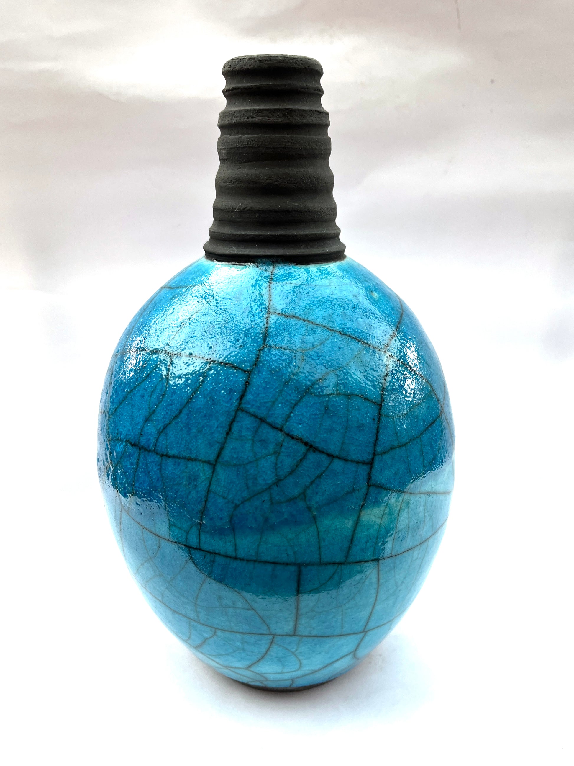 Turquoise raku bottle form with ridged black neck